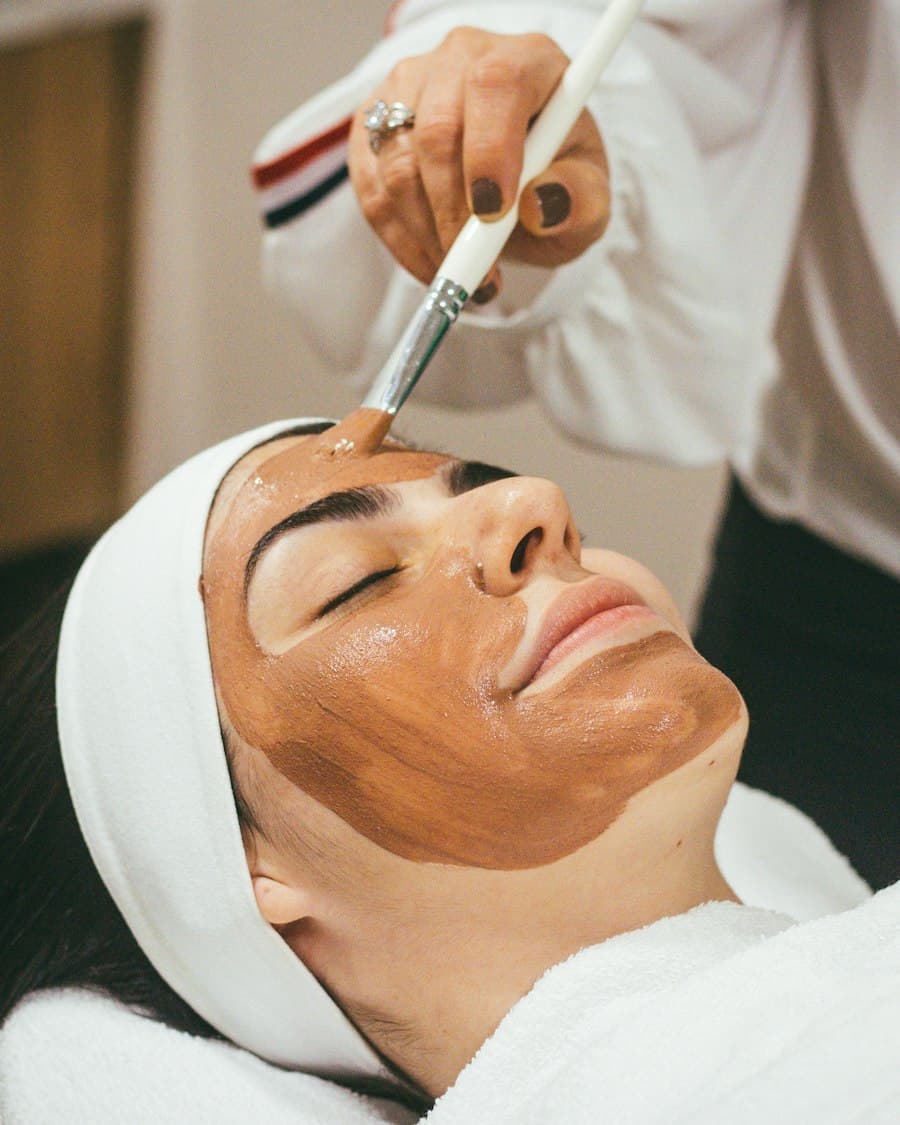 Esthetician applying a brightening facial mask to a client at Aurelle Skin Clinic